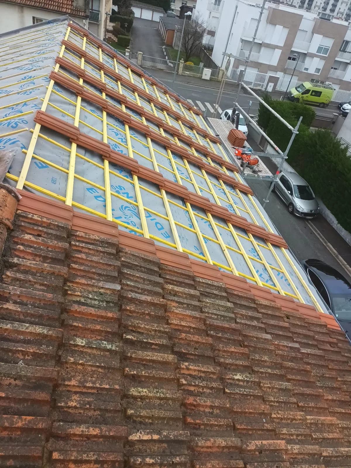 Tuiles neuves posées progressivement lors de travaux de toiture